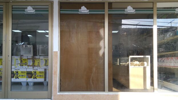 in-manzanillo,-the-windows-of-hard-currency-stores-are-covered-against-stones